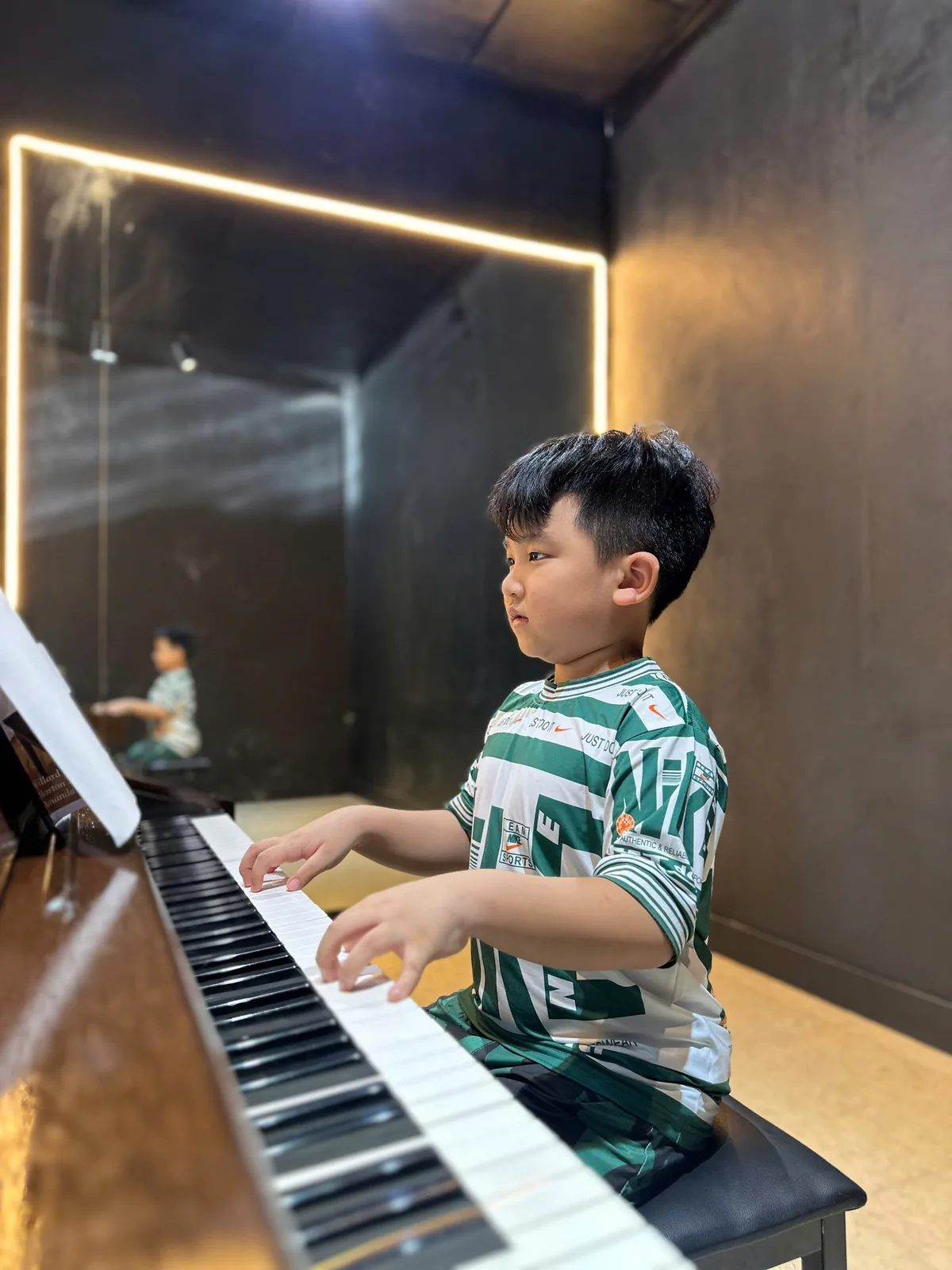 Bé trai tập đàn piano trong hoạt động năng khiếu tại Mầm Non Trí Tuệ Việt